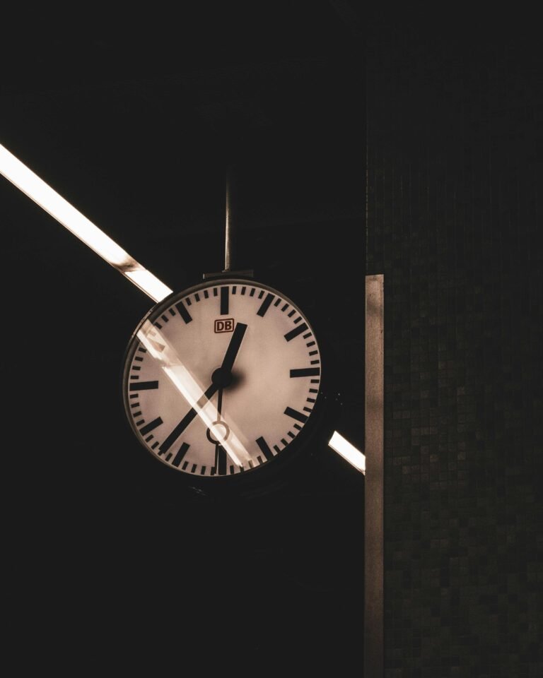 Close-up of a vintage analog clock in a German subway station at night.